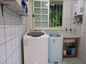 eine Waschmaschine im Bad mit Waschbecken in der Unterkunft Casa ampla e aconchegante em Gramado in Gramado + 21 Fotos