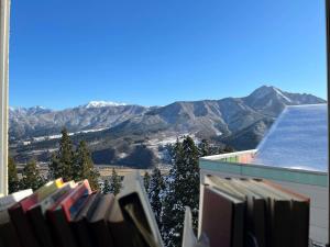 uma vista para as montanhas a partir de uma varanda com livros em Ishiuchi Ski Center em Minami Uonuma