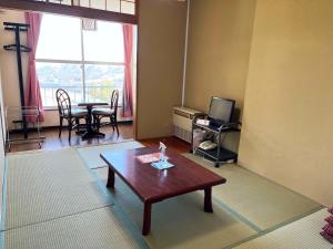 a living room with a coffee table and a television at Ishiuchi Ski Center in Minami Uonuma