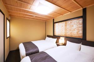 two beds in a room with two windows at Rinn Fushimiinari in Kyoto