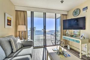 a living room with a couch and a tv at Dreamy Beach Condo with Views and Amenity Access! in Myrtle Beach