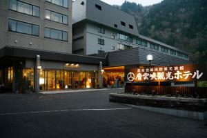 a building with a sign in front of it at Sounkyo Kankou Hotel in Kamikawa