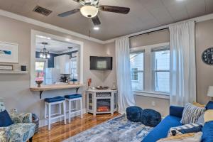 sala de estar con sofá azul y cocina en Central Cottage with Grill, 1 Mi to Cajun Field, en Lafayette