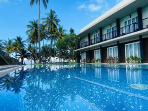 a swimming pool in front of a building at Golden Star Beach Hotel in Negombo