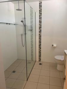 uma casa de banho com um chuveiro e um WC. em New England Motor Lodge em Glen Innes