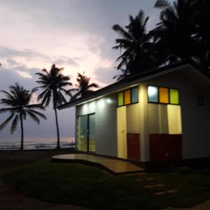 ein Haus am Strand mit Palmen im Hintergrund in der Unterkunft Baan Be Beach in Lang Suan