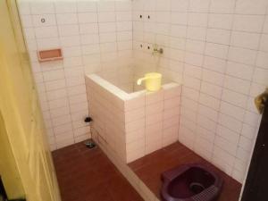 ein Bad mit WC in einem gefliesten Zimmer in der Unterkunft Nguntara Gati in Sleman
