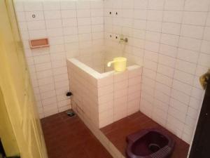 a bathroom with a toilet in a tiled room at Nguntara Gati in Sleman