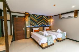 a hotel room with a bed and a dresser at ChaoKoh Phi Phi Hotel and Resort- SHA Extra Plus in Phi Phi Don