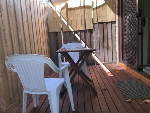 einen Stuhl und einen Tisch auf einer Veranda in der Unterkunft Evancourt Motel Malvern East in Melbourne