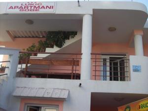 a building with a balcony and a sign on it at Lukic Apartmani in Bar