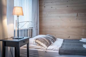 1 dormitorio con 1 cama y 1 mesa con lámpara en Willa Fryzowiczówka, en Zakopane