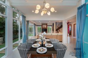 a dining room with a table and chairs at Simantra Private Villas in Cha Am