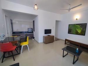 a living room with a table and chairs and a television at Mizzle in Lonavala
