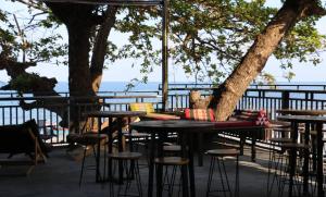 a group of tables and stools on a patio at Phangan Mantra Inn in Haad Rin