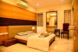 a bedroom with a large bed and a chair at Mizzle in Lonavala