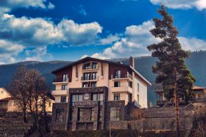 un grande edificio bianco con un cartello sopra di Paliani Hotel a Mestia