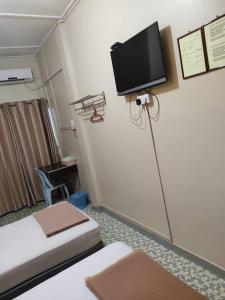 a room with two beds and a tv on the wall at Marina Hotel Kemaman in Kampong Kemaman +15 photos
