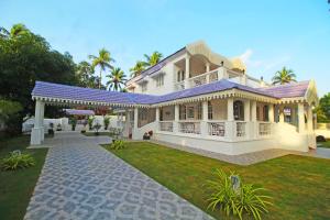 a large white house with a large yard at Villa Beleza Infinita in Mapusa