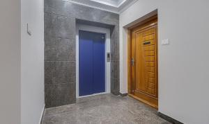 a hallway with a blue door and a stone wall at Treebo Rithikha Inn Elite Chennai Trade Centre in Chennai