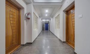 a hallway with two wooden doors and a blue door at Treebo Rithikha Inn Elite Chennai Trade Centre in Chennai