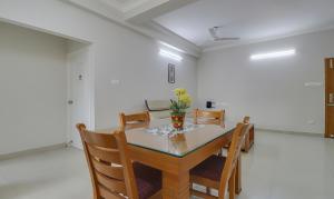 uma sala de jantar com mesa e cadeiras em Treebo Trend Rithikha Inn Elite Chennai Trade Centre em Chennai