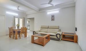 a living room with a couch and a table at Treebo Trend Rithikha Inn Elite Chennai Trade Centre in Chennai