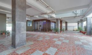 an empty lobby with plants in a building at Treebo Rithikha Inn Elite Chennai Trade Centre in Chennai +28 photos