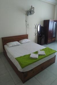 een slaapkamer met een groot bed en 2 handdoeken bij Happy Hotel Binh Chanh in Bình Chánh