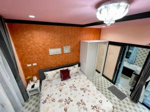 a bedroom with a bed in a room with orange walls at คูร์โดวเเอนด์เเซนด์วิลล่า in Kiriwong