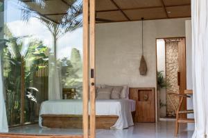 een slaapkamer met een bed en een glazen schuifdeur bij Las Lunas Villas Canggu in Canggu