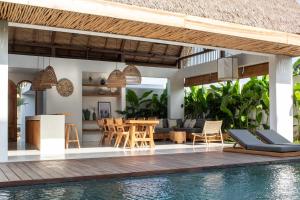 een villa met een zwembad en een eethoek bij Las Lunas Villas Canggu in Canggu