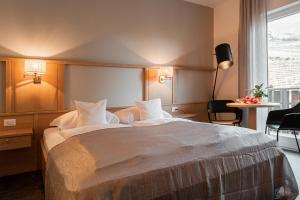 シェーナにあるApartmenthotel Ritterhof Suites & Breakfastの大きなベッドと窓が備わるホテルルームです。