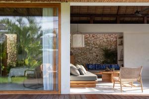 een woonkamer met een bank en een glazen deur bij Las Lunas Villas Canggu in Canggu