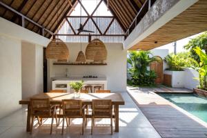 een buitenkeuken en een eetkamer met een tafel en stoelen bij Las Lunas Villas Canggu in Canggu