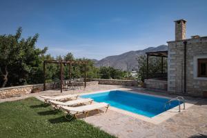 una piscina con tumbonas junto a una casa en Koules Estate, simplicity & natural, By ThinkVilla, en Argoulión