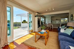 a living room with a blue couch and a table at Scarborough Heights in Kaikoura