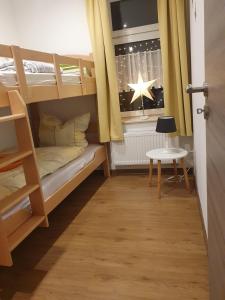 a room with bunk beds with a window and a table at Ferienwohnung-Am-Markt in Harzgerode