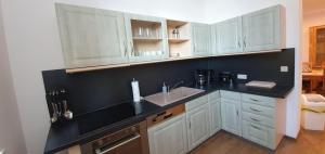 a kitchen with white cabinets and a black counter top at Ferienwohnung-Am-Markt in Harzgerode +26 photos