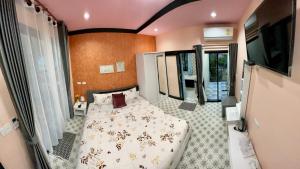 a bedroom with a bed and a television in it at คูร์โดวเเอนด์เเซนด์วิลล่า in Kiriwong