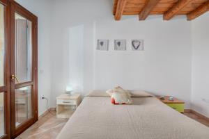 ein weißes Schlafzimmer mit einem großen Bett in einem Zimmer in der Unterkunft Trilo Orizzonti 31 in Golfo Aranci