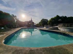 una piscina di acqua blu con una statua sullo sfondo di Libertyland Waterpark Resort by Cocotel a Mabalacat