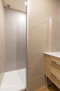 a shower with a glass door in a bathroom at 153 Rue des Rochers in Lanslevillard