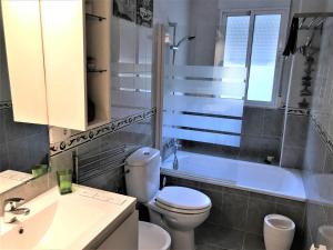 een badkamer met een toilet, een bad en een wastafel bij Apartamento junto al río en entrada ruta Cahorros in Monachil