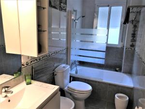 a bathroom with a toilet and a tub and a sink at Apartamento junto al río en entrada ruta Cahorros in Monachil