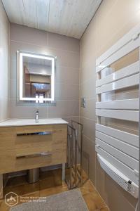ein Bad mit einem Waschbecken und einem Spiegel in der Unterkunft 153 Rue des Rochers in Lanslevillard