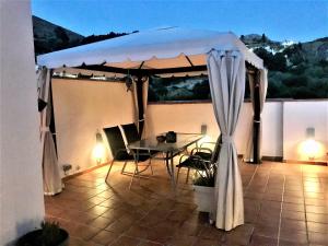 een patio met een tafel en een tent bij Apartamento junto al río en entrada ruta Cahorros in Monachil