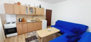 a living room with a blue couch and a kitchen at Vinara Kupres in Kupres