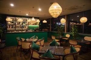 a restaurant with tables and chairs and a bar at The Bloom Hanoi in Hanoi