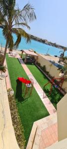 a garden with a table and a chair on the grass at فيلا بمسبح خاص درة العروس in Durat  Alarous